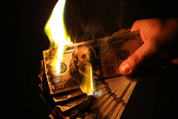 Adam parayı yakıyor. Dolar fotoğrafı. Açgözlü yozlaşma kavramı. Rüşvet fikri. Enflasyon oranları. Fiyat artışı.