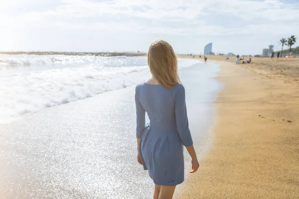 身穿蓝色衣服的漂亮姑娘正在海滩上散步 令人惊奇的夏季照片 靠近大海的女人快乐和有趣的情绪 假日旅行的概念 温暖的海水 — 图库照片