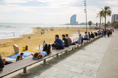 BARCELONA, İspanya - 15 Ekim 2018 Barcelona sahilinde yürüyen insanlar. Yaz tatili seyahatleri. Sonbaharda Barceloneta. Turistler dinleniyor..