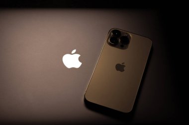 KYIV, UKRAINE - 20 Ekim 2023: Modern akıllı telefon Apple iPhone 15 Pro ve Apple Macbook Pro laptop. Cupertino teknoloji aletleri. Marka logosu adı.