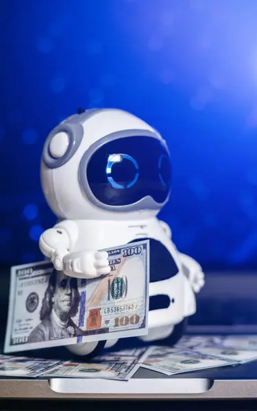 Real robot with dollars money on laptop. Modern digital technology concept. Artificial intelligence as an aid in making money. Business development with digitalization.