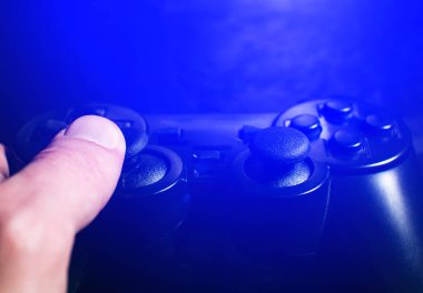 Adam Black Gamepad 'de bilgisayar oyunları oynuyor ve düğmelere ve analoglara basıyor, kapat.