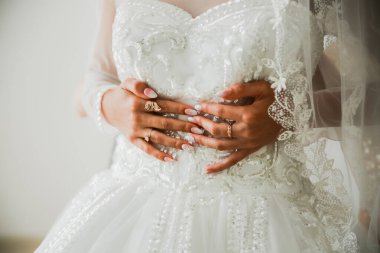 Gelin lüks bir elbise giyiyor. Altın yüzüklü eller. Güzel tırnaklar. Yapay kristal elmaslar. Düğün mücevherleri..