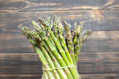 Ahşap arka planda yeşil bir kuşkonmaz sürüsü. Sağlıklı diyet yemekleri. Vejetaryen yemeği..