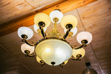 Tavanın altında eski model hafif avize..