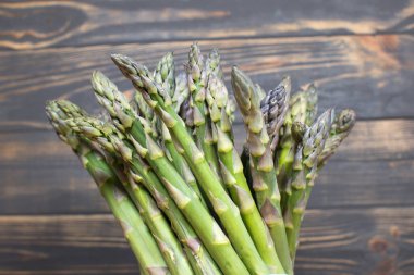 Ahşap arka planda yeşil bir kuşkonmaz sürüsü. Sağlıklı diyet yemekleri. Vejetaryen yemeği..