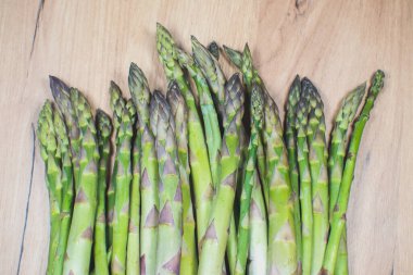 Ahşap arka planda yeşil bir kuşkonmaz sürüsü. Sağlıklı diyet yemekleri. Vejetaryen yemeği..