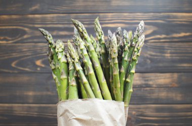 Ahşap arka planda yeşil bir kuşkonmaz sürüsü. Sağlıklı diyet yemekleri. Vejetaryen yemeği..
