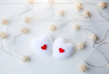 Ahşap arka planda kırmızı ve beyaz kalpler. Sevgililer Günü konsepti. Aşk ve romantik fotoğraf. Tatil için kartpostal. Küçük kırsal ışıklar.