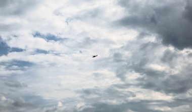 Gri bulutlar. Gökyüzünde uçan bir helikopter..