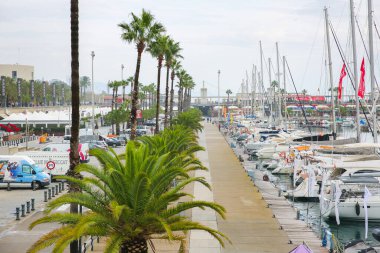 BARCELONA, İspanya - 15 Ekim 2018 Barcelona 'da yatları olan liman. Deniz kenarındaki gri gökyüzü. Gemiler. Turistik yerler.