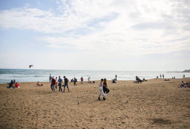 BARCELONA, İspanya - 15 Ekim 2018 Barcelona sahilinde yürüyen insanlar. Yaz tatili seyahatleri. Sonbaharda Barceloneta. Turistler dinleniyor..