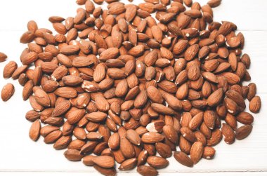 Beyaz arka planda duran badem fıstıkları. Sağlıklı yiyecekler. Vejetaryen konsepti. Yaşam tarzı. Dikey.