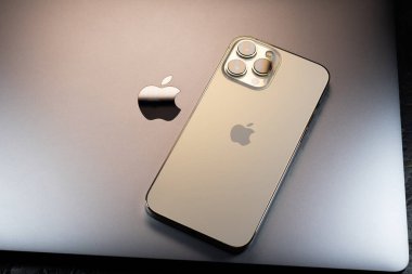 KYIV, UKRAINE - 20 Ekim 2023: Modern akıllı telefon Apple iPhone 15 Pro ve Apple Macbook Pro laptop. Cupertino teknoloji aletleri. Marka logosu adı.