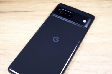KYIV, UKRAINE - 03 Ekim 2023: Modern akıllı telefon Google Pikseli ahşap masa arkasında.