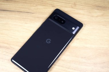 KYIV, UKRAINE - 03 Ekim 2023: Modern akıllı telefon Google Pikseli ahşap masa arkasında.