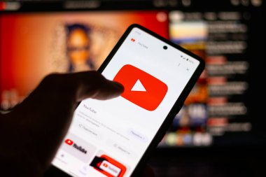 Kapat, Adam ekranda sosyal internet servisi Youtube 'u olan bir akıllı telefon tutuyor..