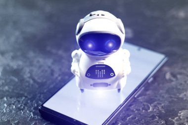 Akıllı telefondan beyaz arka planı olan çok küçük bir robot. Geleceğin teknolojisi. Gelişim için iş yardımcısıyım. Çevrimiçi yardımcı, sohbet bot.