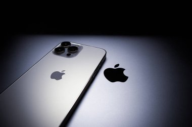 KYIV, UKRAINE - 20 Ekim 2023: Modern akıllı telefon Apple iPhone 15 Pro ve Apple Macbook Pro laptop. Cupertino teknoloji aletleri. Marka logosu adı.