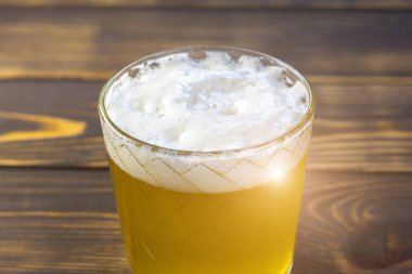 Beyaz köpüklü altın sarısı bira bardağa. Görüntüyü kapat.