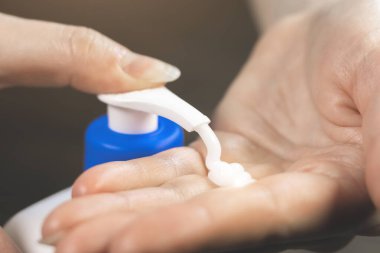 Kadın elindeki kavanozdan beyaz nemlendirici krem sıkıyor. Kozmetik, cilt bakımı, güzellik tedavisi. Görüntüyü kapat.