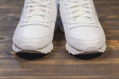 Ahşap arka planda Modern Beyaz Klasik Deri Ayakkabılar veya Spor Ayakkabılar.