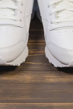 Ahşap arka planda Modern Beyaz Klasik Deri Ayakkabılar veya Spor Ayakkabılar.