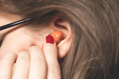 Kadın kulaklığa Orange Wireless Bluetooth kulaklığı yerleştiriyor. Modern Stereo Kulaklıklar, Spor Kulaklık.