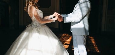 Gelin ve damat sarayda kollarını tutuyor. Aşık düğün çifti. Lüks elbise. Eski ahşap merdivenler