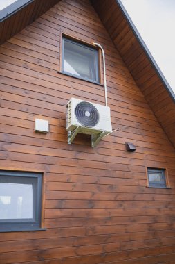 Modern ahşap evin duvarına kompresörlü klima yerleştirilmiş..