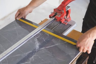 İşçi kesim için seramik fayans ölçer. Dairede bakım onarımı var. Yenileme işlemi.