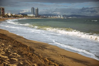 Güneşli bir günde güzel bir sahil. Denizde dalgalar. Tatil seyahati konsepti. Barselona İspanya görüşleri.