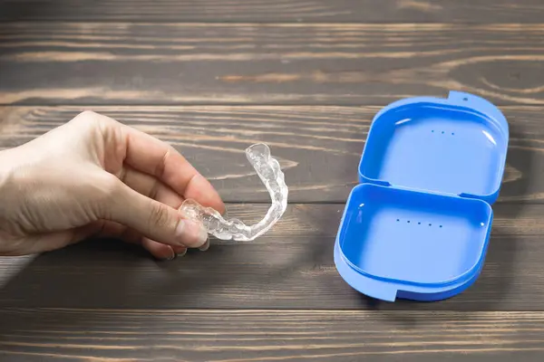 stock image Woman takes Dental splint mouth guard from the box. TMJ splint disorder treatment. Occlusal splint. Prevent bruxism. Mouth guard for TMJ. Teeth protection. Pain in jaw. Teeth grinding.