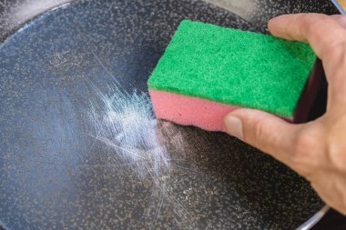 Tabakları çizik teflon kaplamalı tencerede yıkamak için sünger. Yemek takımında tehlikeli kimyasallar var. Yan soyuluyor..