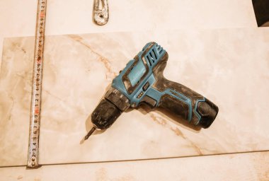 Dairede elektrikli matkap ve paneller var. Bakım onarımı, parşömen testeresiyle dairede tadilat yapıyor. Kapalı alandaki fayansların restorasyonu.