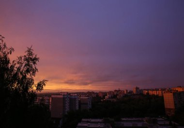 Şehrin üzerinde güzel bir günbatımı. Mor gökyüzü renkleri.
