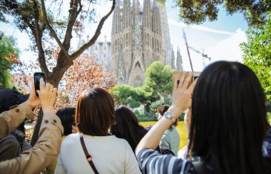 BARCELONA, İspanya - Ekim 2018: Sagrada Familia Kilisesi yakınlarında fotoğraf çeken turistler. Güneşli bir gün. Ünlü mimari tasarımı. Seyahat konsepti gezisi.