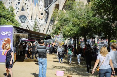 BARCELONA, SPAIN - OCTOBER, 2018: Tourists walking near the church of Sagrada Familia. City life. Sunny day. Travel concept sightseeing.