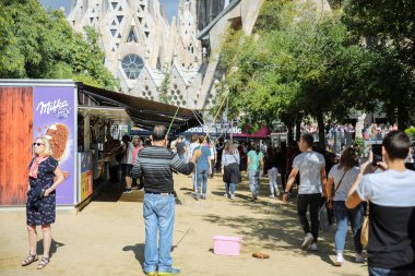 BARCELONA, İspanya - Ekim 2018: Sagrada Familia Kilisesi 'nin yakınında yürüyen turistler. Şehir hayatı. Güneşli bir gün. Seyahat konsepti gezisi.