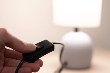 İnsanlar modern gece lambası düğmesini açıyor. Kitap okumak için yatak başı lambası. Kapat..