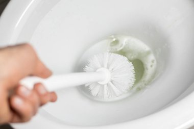 İnsanların elinde beyaz tuvalet fırçası. Tuvalet temizleme konsepti. Kapat..