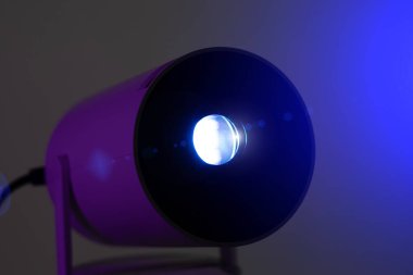 Yakın çekim, modern kablosuz video projektörünün mavi ışığı. Video ya da fotoğraf sunumu ve amatör film izleme.