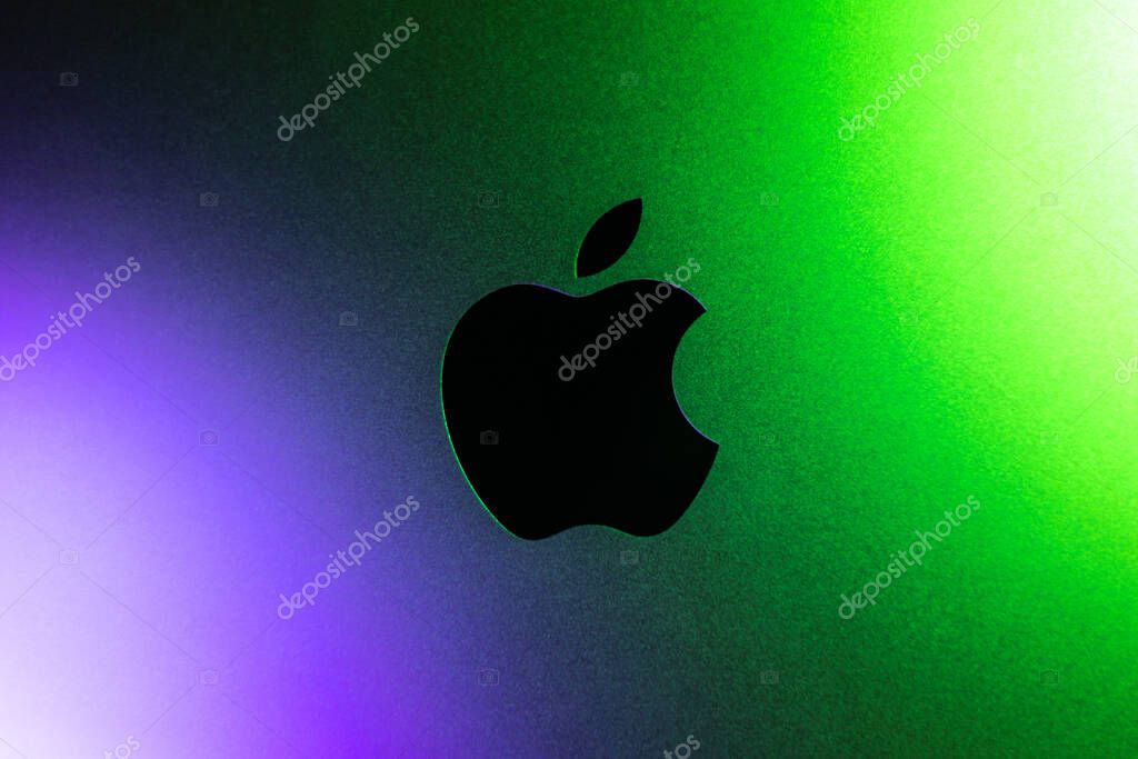 KYIV, UKRAINE - April 15, 2025 :  Apple company logo in neon purple and green lights. Modern technology photo.