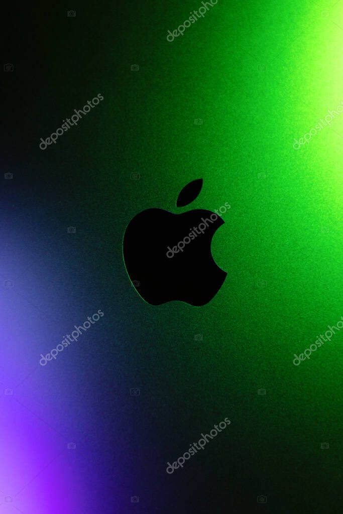 KYIV, UKRAINE - April 15, 2025 : Vertical photo, Apple company logo in neon purple and green lights. Modern technology photo.