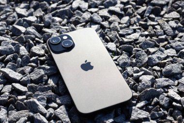 KYIV, UKRAINE - September 26, 2025 : Modern smartphone Apple iPhone on gray stones outdoors.