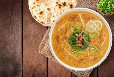 Beef Haleem 'in naan ve ahşap arka planlı üst görüntüsü.