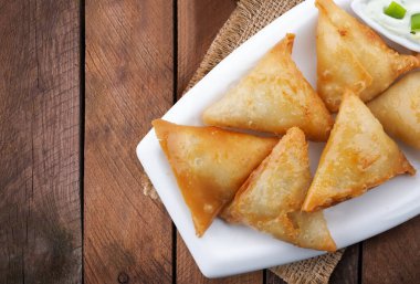 Üst manzara aloo ve tavuk samosas arka ahşap arka plan.