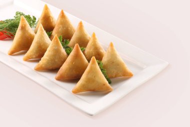 Beyaz arka planda izole edilmiş Patates Samosa çerezleri. Hint Ramazan Yemeği, Pakistan iftar yemeği.