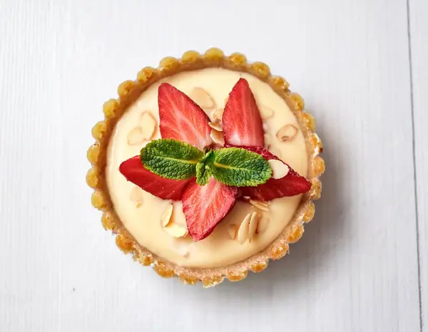 stock image Tartlets with custard vanilla cream with fresh berries and mint on a gray concrete background. Summer dessert. ai generated