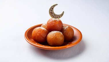 Eid Mubarak and Ramadan creative concept design. Indian Sweet Motichoor laddoo and Gulab jamun with a crescent moon on top. clipart